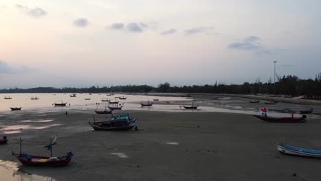 AERIAL:-Asian-Fishing-Boats-stranded-at-low-tide-on-the-coast-at-Sunset