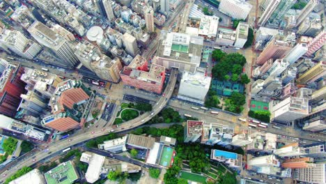 Verkehr,-Der-Durch-Ein-Parkhaus-In-Der-Innenstadt-Von-Hongkong-Führt,-Mit-Megagebäuden-Der-Stadt,-Luftbild