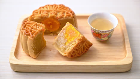 Chinese-moon-cake-durian-and-egg-yolk-flavour-with-tea-on-wood-plate
