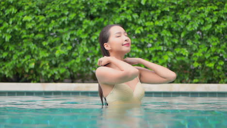 A-beautiful-woman-in-a-swimming-pool-pushes-back-the-wet-hair-from-her-face