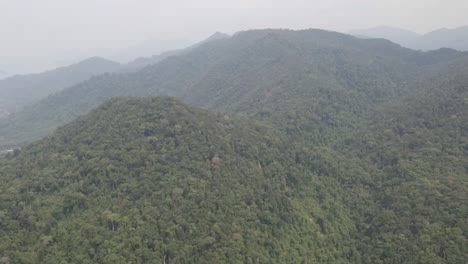 Aerial-drone-pan-shot-of-lush-green-tropical-exotic-rain-forest-jungle-with-thick-smog-and-bad-air-pollution-caused-by-agricultural-burn-off,-on-a-Island-in-Thailand