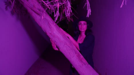 Gorgeous-Woman-Posing-Near-A-Tree-With-Purple-Light-And-Walks-Into-The-Alleyway---Medium-Shot