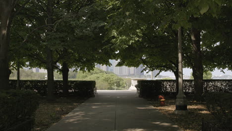Push-down-tree-lined-walkway-in-park-towards-Lake-Michigan-and-Chicago-city-skyline