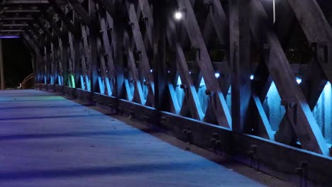Slowly-pulsating,-decorative-coloured-lights,-illuminate-a-pedestrian-bridge-at-night