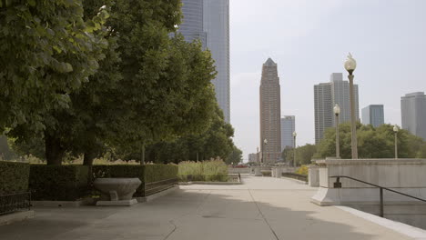 Slow-push-down-sidewalk-past-trees-towards-buildings-in-Chicago-on-a-pretty-summer-day