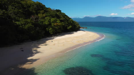 Revealing-drone-shot-of-beautiful-tropical-beach-and-blue-water-at-Fitzroy-Island-Australia