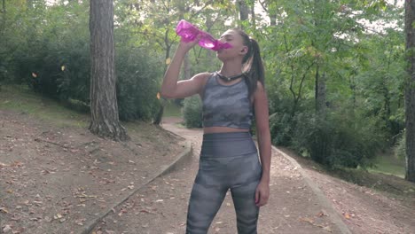 Girl-drinking-water-from-a-bottle-while-resting-after-a-training