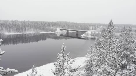 Frozen-Bridge-crossing-the-Vindel-River-near-Snowy-forest-in-Björksele,-Västerbotten,-Sweden