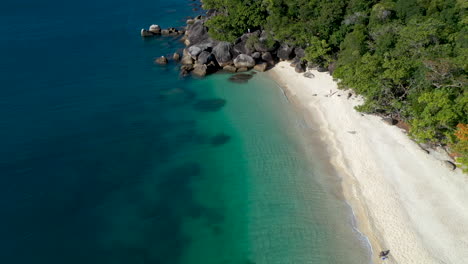 Revealing-drone-shot-of-an-Fitzroy-Island-beach-in-Australia-with-people-on-the-beach