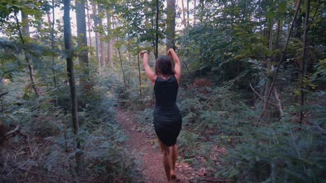 Follow-up-shot-of-young-happy-girl-grooving,-dancing-and-enjoying-her-holiday-amidst-dense-greenery