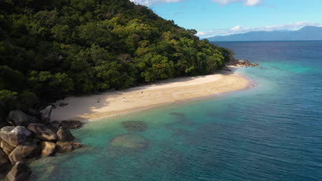 Wide-rotating-drone-shot-of-woman-walking-on-Nudey-Beach-on-Fitzroy-Island