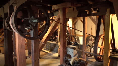 Handheld-Wide-shot-inside-old-heritage-Mill---spinning-wheels-with-transmission