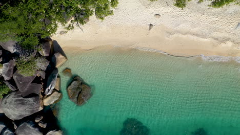 Rising-drone-shot-of-clear-blue-ocean-water-at-Fitzroy-Island-in-Australia