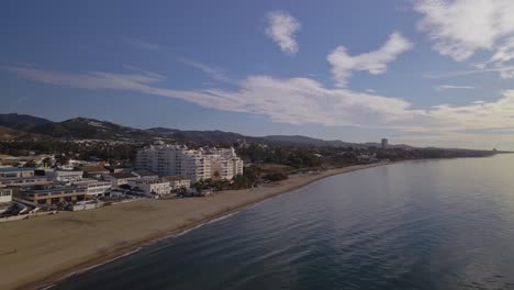 Aerial-4K-view-of-city-on-the-coastline-panning-into-the-sea