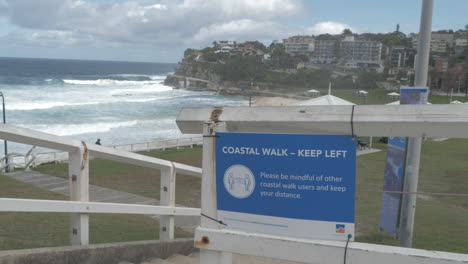 Bronte-Beach-Coastal-Walk-Fence-With-Social-Distancing-Sign---Coronavirus-Outbreak-In-Sydney,-NSW,-Australia