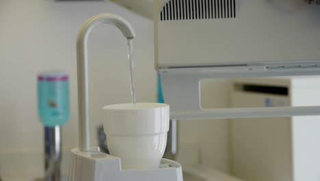 A-cup-for-rinsing-is-automatically-filled-with-water,-at-the-dentist