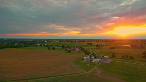 Vista-Aérea-De-La-Puesta-De-Sol-Sobre-Las-Tierras-De-Cultivo-Amish-En-Pennsylvania-En-Junio
