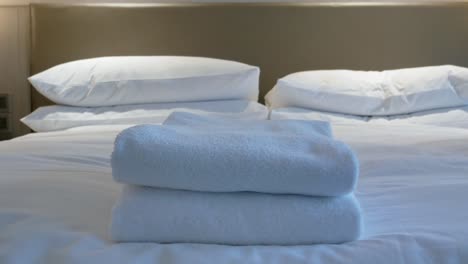 Housekeeper-is-putting-towel-on-the-bed-in-the-room