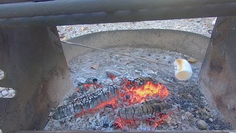 Large-white-marshmallow-turning-brown-while-roasting-over-a-campfire