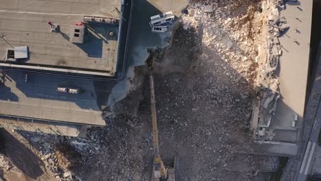 Aerial-view-of-an-Excavator-drilling-and-demolishing-the-concrete-wall-of-building-or-apartment