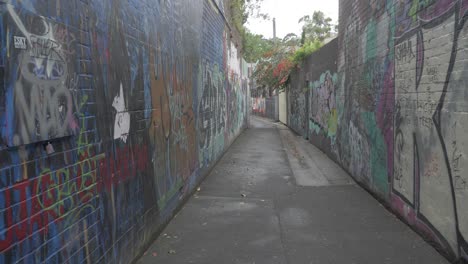 Empty-Alley-Way-With-Colorful-Graffiti-Arts-On-Concrete-Wall---sideway-shot