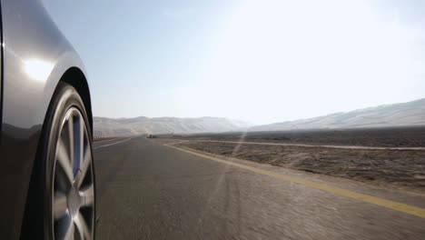 Autoradperspektive,-Fährt-über-Weiß-gelbe-Zebrastreifen-Und-Rast-In-Die-Wüste