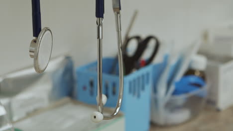 Doctor-stethoscope-hangs-in-foreground-over-sterile-medical-workspace,-close-up