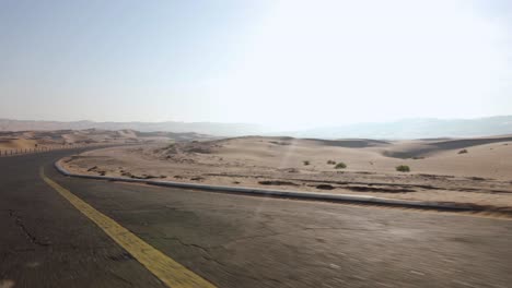 Driving-down-an-empty-Road-into-the-beautiful-Abu-Dhabi-Sand-desert-on-a-hot-day