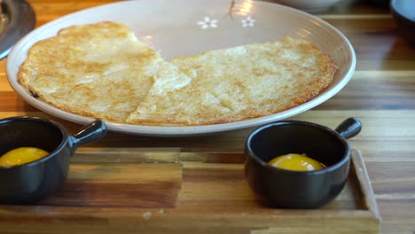 Traditional-Korean-pizza-with-egg-yolk-served-on-side,-slider-motion