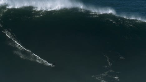 Slow-motion-of-a-big-wave-surfer-riding-a-monster-wave-in-Nazaré,-Portugal