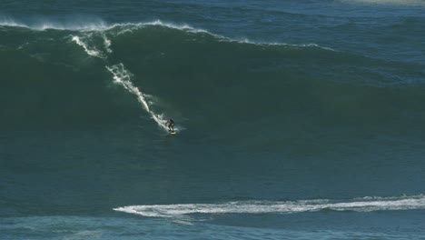 Slow-motion-of-a-big-wave-surfer-Caio-riding-a-monster-wave-in-Nazaré,-Portugal