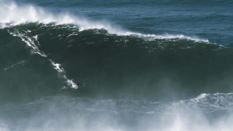 Slow-motion-of-a-big-wave-surfer-riding-one-of-the-biggest-monster-waves-in-Nazaré,-Portugal