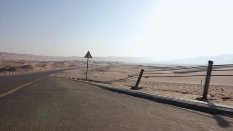 Car-drives-through-amazing-Sand-Dunes-of-Abu-Dhabi-desert-with-camera-side-mounted