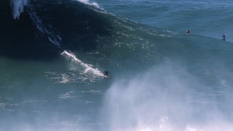 Slow-motion-of-a-big-wave-surfer-riding-one-of-the-biggest-waves-of-the-season-in-Nazaré,-Portugal