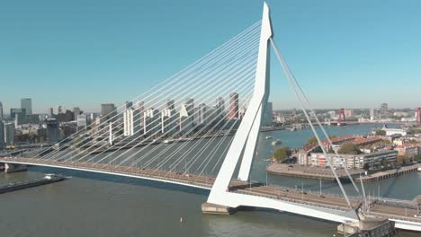 Aerial-drone-footage-of-the-Erasmus-Bridge,-The-Swan,-crossing-over-the-few-water-channels-of-Rotterdam,-Netherlands