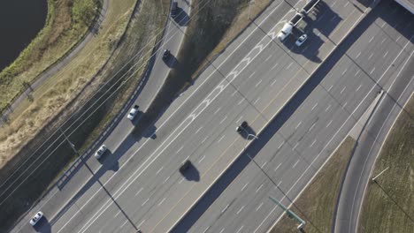 freeway-instersection-connection-at-a-drone-aerial-birds-eye-view-of-steady-traffic-of-cars-and-a-double-oil-tanker-generic-truck-on-route-to-import-export-a-commercial-delivery-on-a-sunny-sumer-day