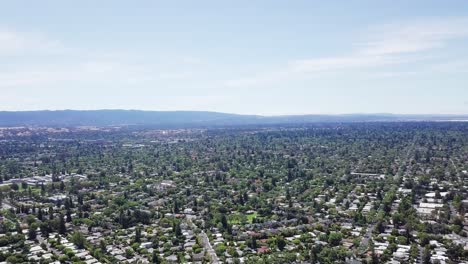 Panoramic-birds-eye-view-of-silicon-valley-suburbs-with-mountains-in-background-and-blue-sky,-crisp-quality-4k-high-resolution-aerial-footage