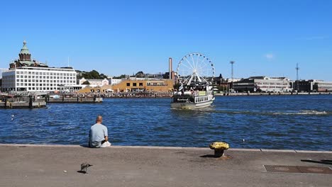 Harbor-Vew-with-Man-sitting-next-to-Water-at-Port-of-Helsinki,-Finland