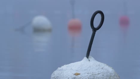 Marine-signalling-buoys-on-boat-Harbour-during-a-cold-foggy-day---Close-up-low-angle-shot