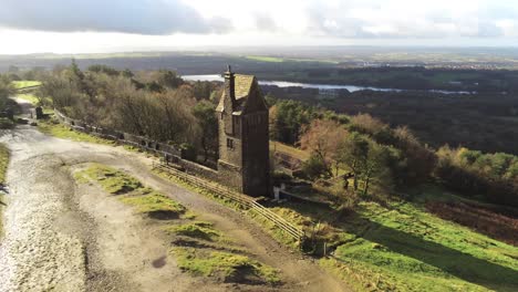 Historic-creepy-fairy-tale-Rivington-pigeon-tower-aerial-slow-right-orbit-low-across-English-Winter-hill-farming-countryside