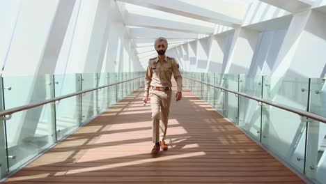 A-Bearded-Indian-Punjab-Police-Officer-Walking-Towards-Camera-With-Stick-In-Hand---Long-Shot