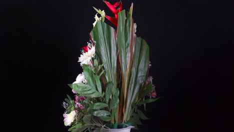 Tropical-cemetery-flower-arrangement-spinning-in-black-background