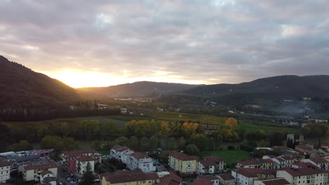 Annäherung-Aus-Der-Luft-Überblick-über-Die-Provinz-Toskana,-Italienische-Landschaft,-Grüne,-Mit-Weinbergen-Bedeckte-Hügel,-Sonnenuntergang-An-Einem-Bewölkten-Tag