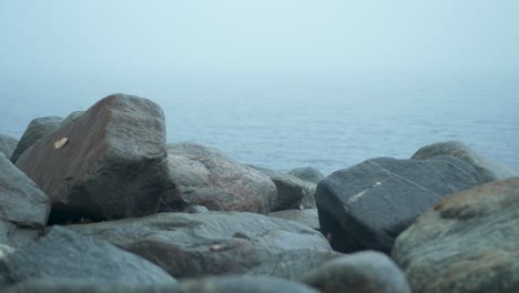 Coastal-Barrier-sea-wall-rocks-on-the-Baltic-sea-under-an-overcast-foggy-moody-day---Push-in-medium-shot
