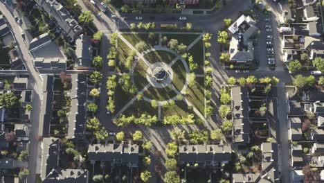 aerial-birds-eye-view-community-park-symetrical-centered-paths-into-a-gazebo-commonly-used-to-celebrate-wedding-and-town-gatherings-around-low-rise-luxury-brick-homes-with-vintage-style-of-sunny-peace