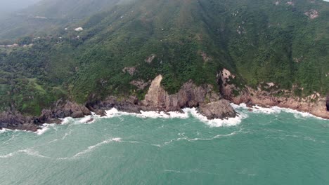 Vista-Aérea-De-Una-Isla-Rocosa-Irregular,-Rodeada-De-Naturaleza-Verde-Y-Exuberante-Y-Agua-De-La-Bahía-De-Hong-Kong