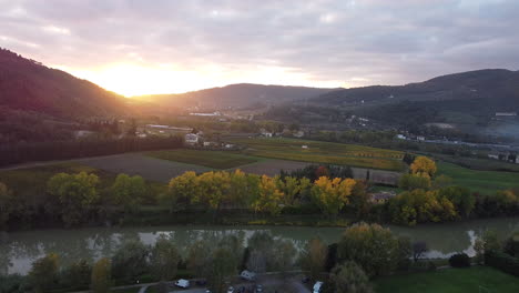 Langsam-Umkreisender-Luftbild-über-Die-Toskanische-Provinz,-Italienische-Landschaft,-Grüne,-Mit-Weinbergen-Bedeckte-Hügel,-Sonnenuntergang-An-Einem-Bewölkten-Tag