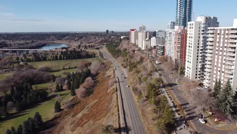 aerial-fly-over-rivers-edge-vip-golf-course-park-in-the-fall-edged-with-high-rise-condomiums-apartments-and-commercial-building-with-a-roadside-access-to-the-freeway-highway-groat-bridge-summer-1-3