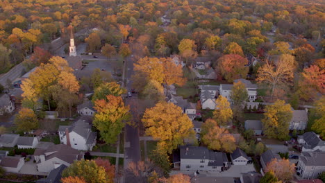 Aerial-push-down-pretty-street-in-Kirkwood,-Missouri-in-the-Fall-at-golden-hour