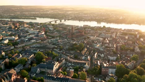 Leaving-Mainz-shot-from-a-drone-in-the-sky-on-a-perfect-summer-sunny-morning-showing-the-old-Town-the-Dome-and-the-river-in-the-background-by-a-wide-cine-drone-in-Germany